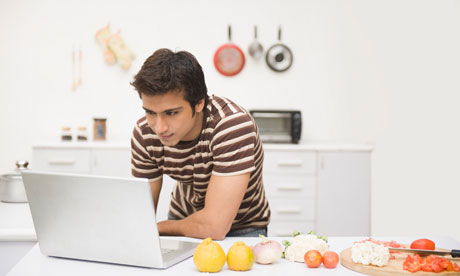 Man using a laptop on a kitchen counter