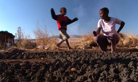 Children play with patties made of coal dust in a shantytown near Newcastle, South Africa. Photograph: Jeffrey Barbee