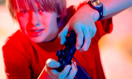 A teeange boy plays on a Sony PlayStation