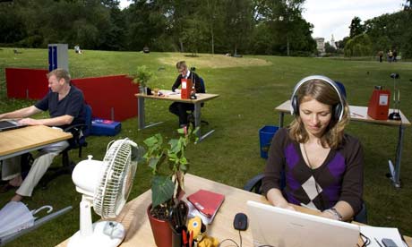 Office workers sit at desks outside