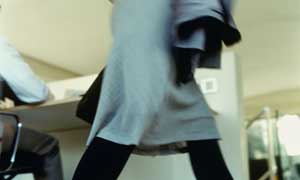 A woman walks past a desk in her office as she leaves