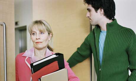 Colleagues pass each other in a doorway