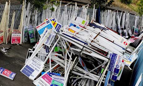 Estate agent signs piled up in a yard