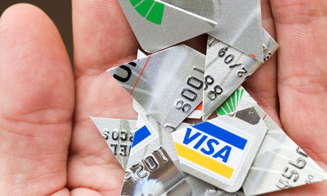 A hand holding pieces of a cut-up credit card