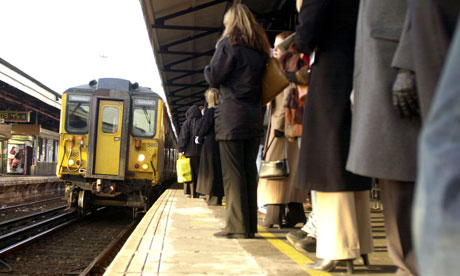 Passengers wait for a train