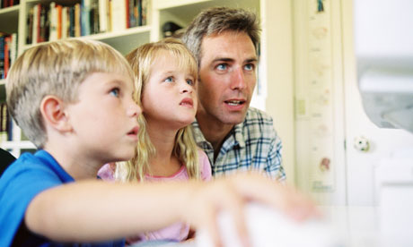 A father and his children looking at a computer