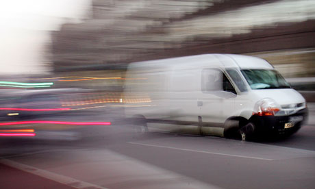 A white van drives through traffic