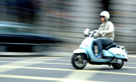 A scooter rider whizzes through London