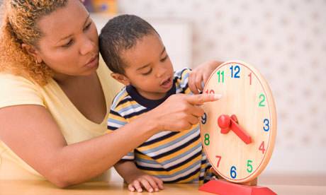 Mother teaching son boy to tell time