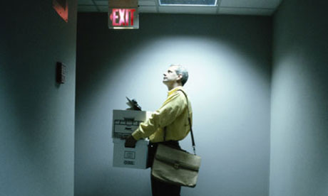 A man waiting for a lift holding boxes after leaving his job