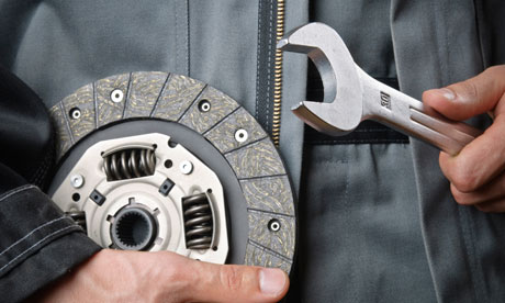 A car Mechanic with spanner and clutch plate