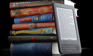 A Kindle and a pile of books