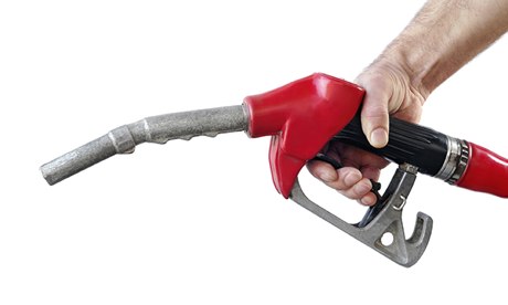 Hand holding a petrol pump against a white background