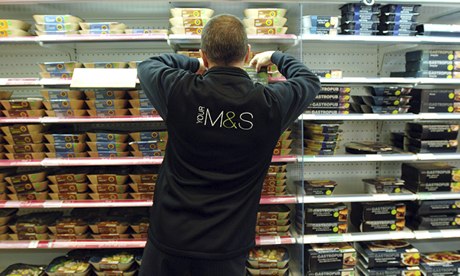 A member of staff stacks a fridge with ready meals at Marks and Spencer