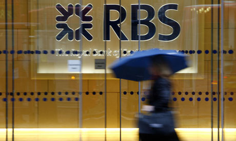 Woman with an umbrella walks in front of office with RBS logo