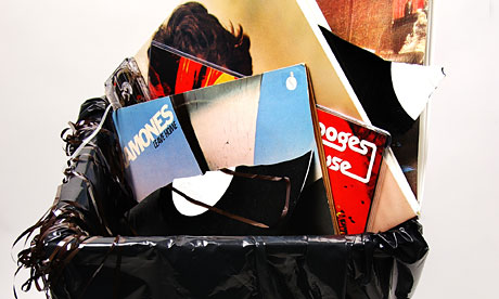 Vinyl records and a casette tape in a bin