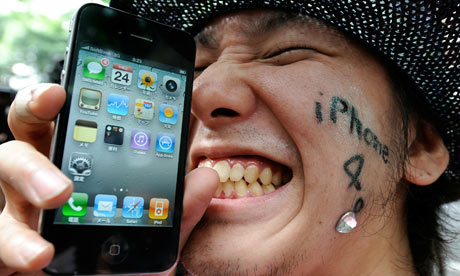 A man holds his iPhone 4 in front of a m