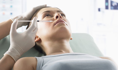 Woman Receiving Plastic Surgery Treatment in Her Lip With a Syringe