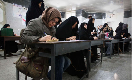 Women fill in their ballots during Iran's parliamentary election, at a mosque in southern Tehran