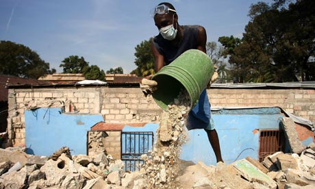Haitians clean up the debris in a house