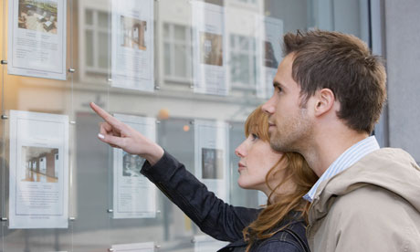 Couple looking in window outside estate agents