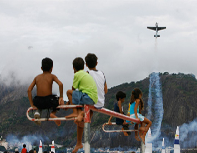 Children watch as a plane perfrom during the Red Bull Air Race
