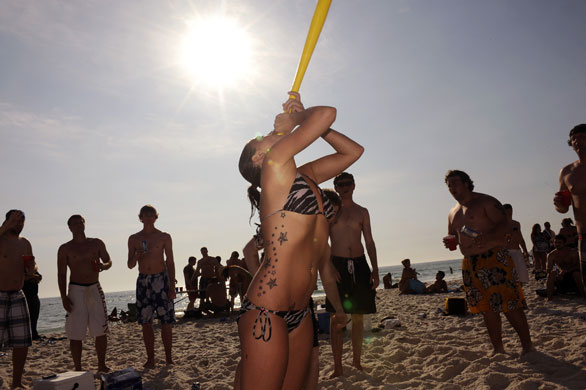Spring break: A girl drinks from a plastic baseball bat