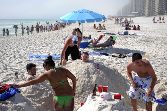 Spring break: Students bury each other in sand on the beach