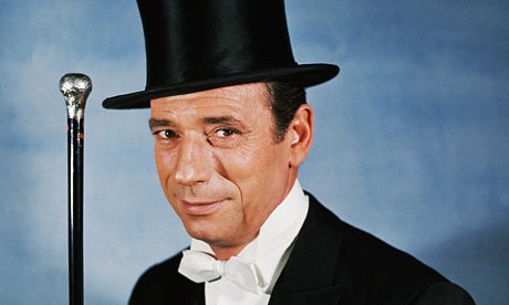 French actor Yves Montand strikes a debonair pose in top hat and white tie