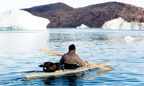 Inuit narwhal hunter paddling kayak on a narwhal hunt at  Inglefield Fjord near Qaanaaq Greenland