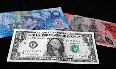 australian dollar bill. A US one-dollar bill below an