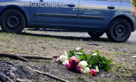 A bouquet of roses is seen on the place where four people were shot dead in the French Alps