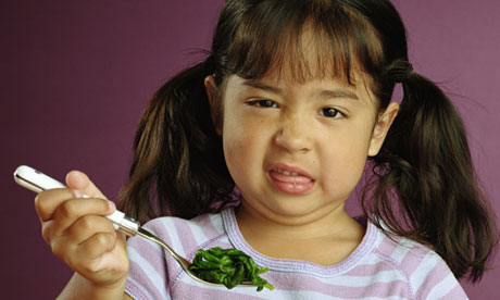 Girl making face at spinach