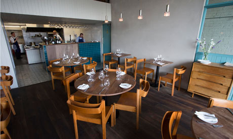 Round tables and wooden chairs at Ox Restaurant in Belfast