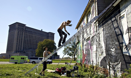 Artists paint the walls of Imagination Station, a house across from Detroit's abandoned train depot.