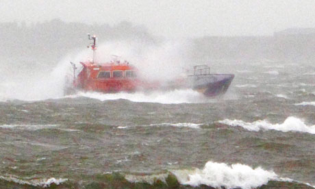 Waves break over a pilot boat