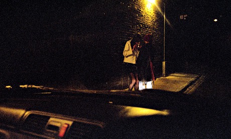 A view from a car of a man and a young girl on a street at  night POSED BY MODELS