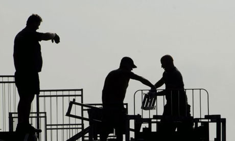 Workers on a construction site building site safety signs. Workers on a construction site