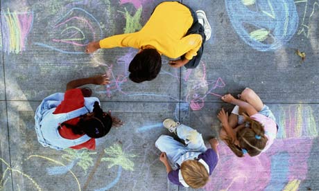 Four children drawing with chalk on pavement. Photograph: Stephen Simpson/Getty Images