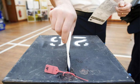 Voter placing card into ballot box