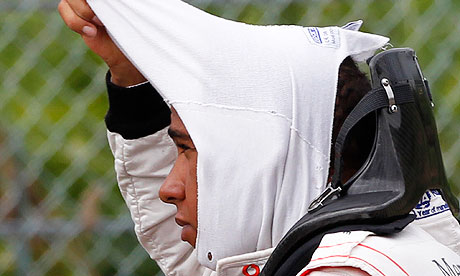 Lewis Hamilton takes off his mask after crashing during practice at the 