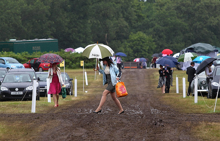 Ascot day 4: A racegoer walks through the mud in her high heels on day 4 of Royal Ascot