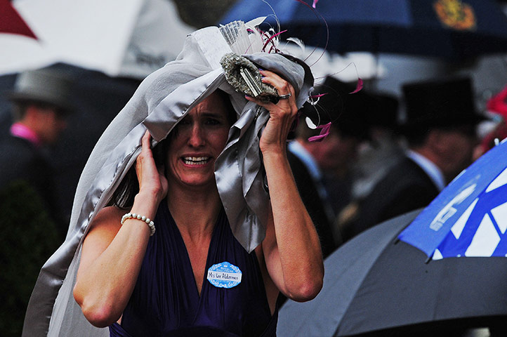 Ascot day 4: Racegoer shelters from the rain