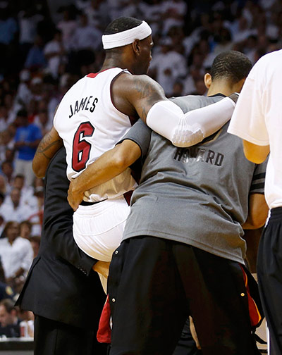 NBA4: Miami Heat's LeBron James is helped off the court