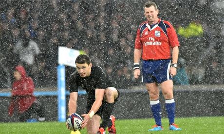 The referee, Nigel Owens, watches as New Zealand's Beauden Barrett lines up a kick against England