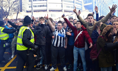 Newcastle fans are marshalled by police as they gesture towards Sunderland supporters before the Tyn