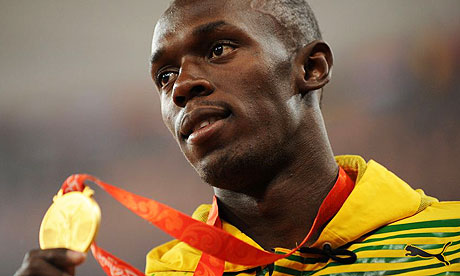 Usain Bolt showing one of his golden olympic medals.