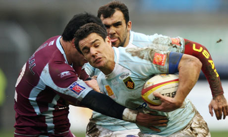 Perpignan's fly-half Dan Carter is tackled by Bourgoin lock Coenie Basson at the Aime-Giral stadium