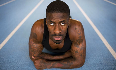 Dwain Chambers looks at the tattoos covering his body as if the blue 