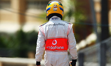 A dejected Lewis Hamilton walks back to the pits after crashing